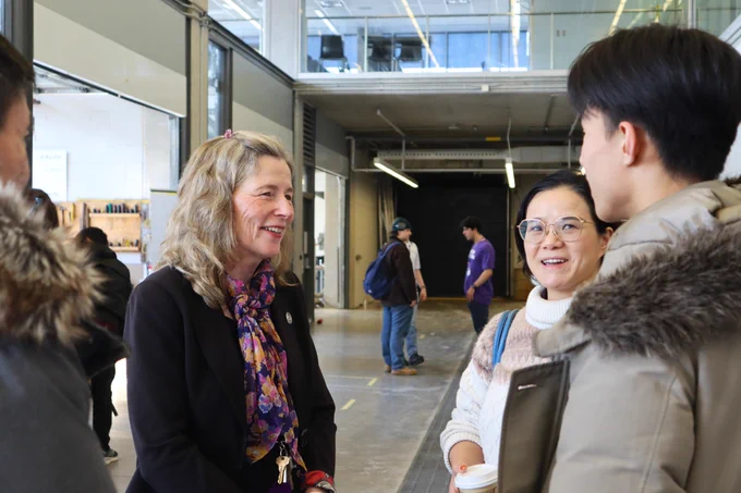 Photo of Dean Mary Wells talking with an interested student and their family.
