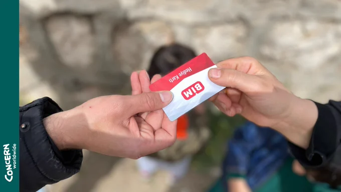 Two hands holding a market card