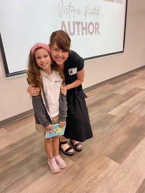 Visiting author Victoria Piontek autographs "Better with Butter" for a student