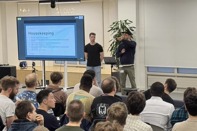A photo of MC Aled with Alex from Monzo giving a welcome speech.