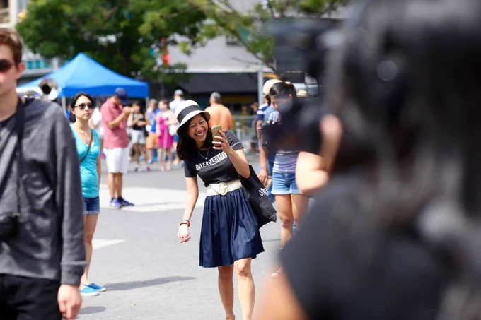 A photo of Tiffany holding her phone at the 2016 New York City Disability Pride Parade