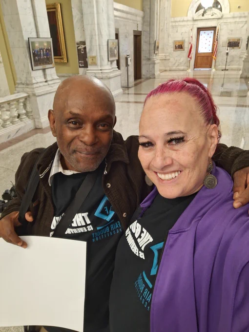 The Way Home Campaign's Robert Warren and Rachelle Ellison take a photo at the Wilson Building before the mayor introduced her budget proposal for Fiscal Year 2025.