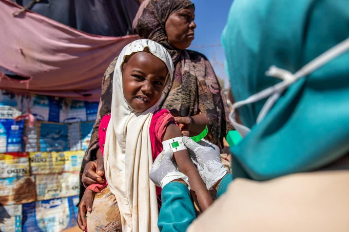 Save the Children’s Family Health Worker, Muna (42), is using a MUAC band to assess the health of a girl in a displacement camp in Somalia. 