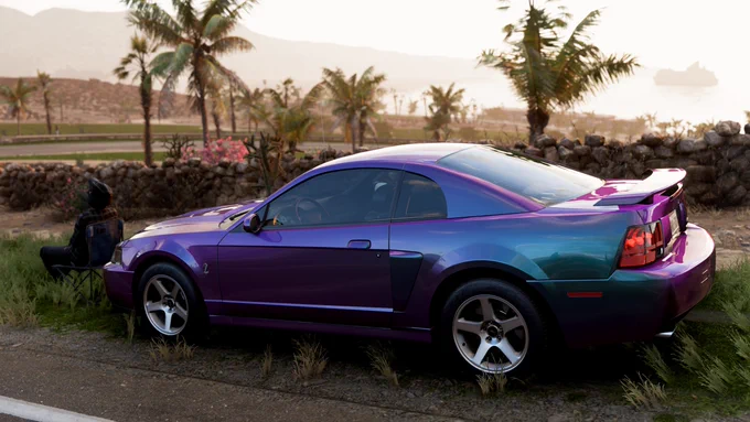A 2003 Ford Mustang SVT Cobra painted in my interpretation of Mystichrome on the side of the road overlooking the Club de Opala de Fuego in Forza Horizon 5.