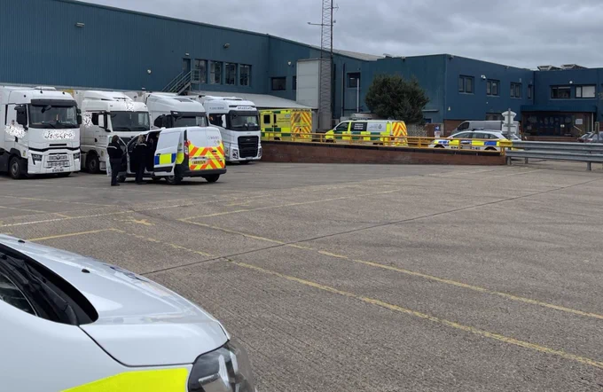 Lorries and police vehicles in a yard