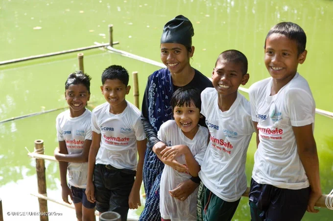 Mim poses with her students who come to her for swimming lessons.