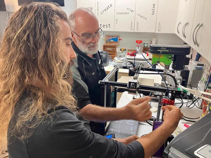 Male student with male professor in a lab working on a project