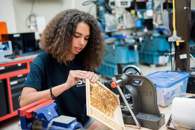 Sabrina Hare '22 holds a lasercut wooden map of the city of Barcelona. 