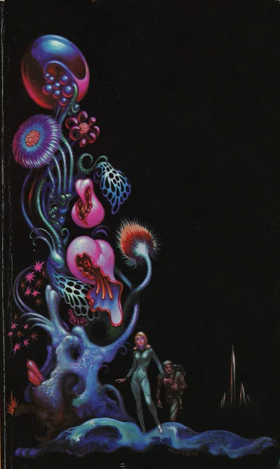 A woman and a man in body suits stand to the right of a big multicolored plant full of weird shaped flowers. A silver rocketship is parked behind them.