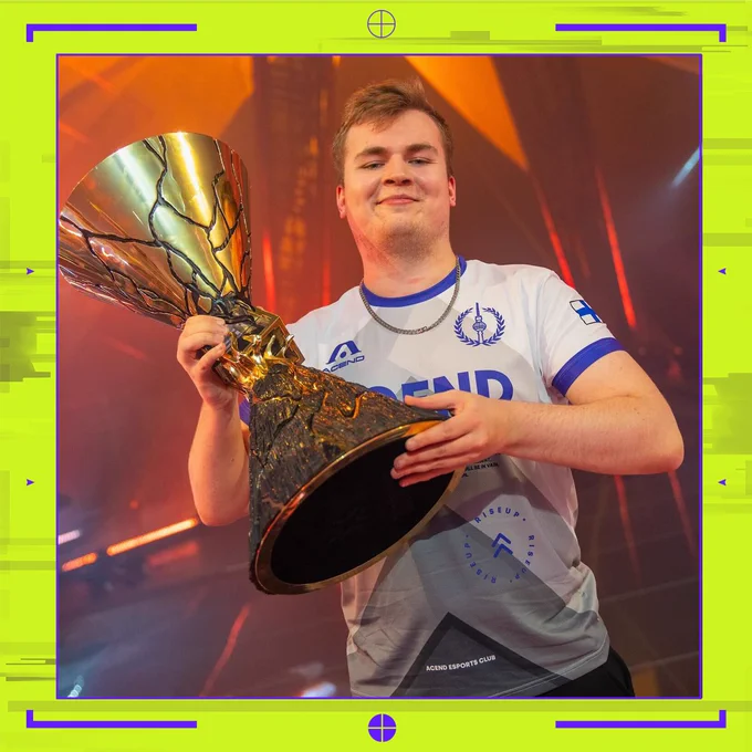 Former VCT Champions winner Bonecold holding the Champions trophy on a stage with red and orange lighting