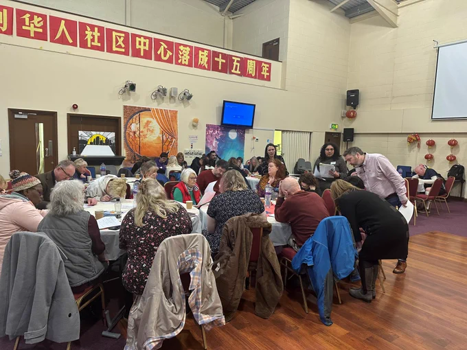 A group of people sat around a table inside the Tees Valley Chinese Community Centre
