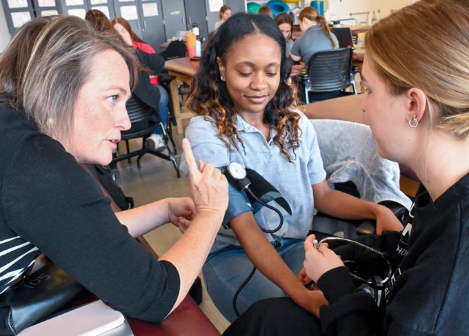 UIndy students practice measuring a patient's blood pressure