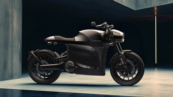 A sleek, modern profile of the Tarform Luna electric motorcycle in a brutalist settings with dramatic lighting.