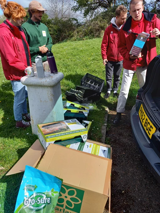 People from Plymouth City Council and National Trust standing next to boxes containing tree nursery kits.