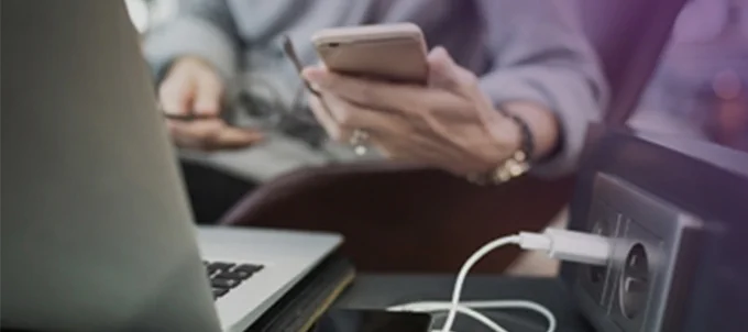 Person med dator och mobiltelefon.
