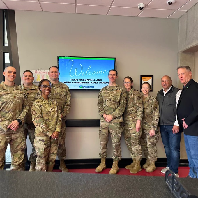 The team standing together with Envision leaders next to a welcome sign.