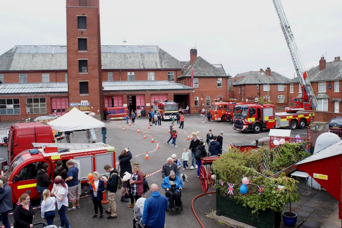 Photo of a previous open day at the Fireground Museum. It shows several engines on the car park and lots of people looking round. 