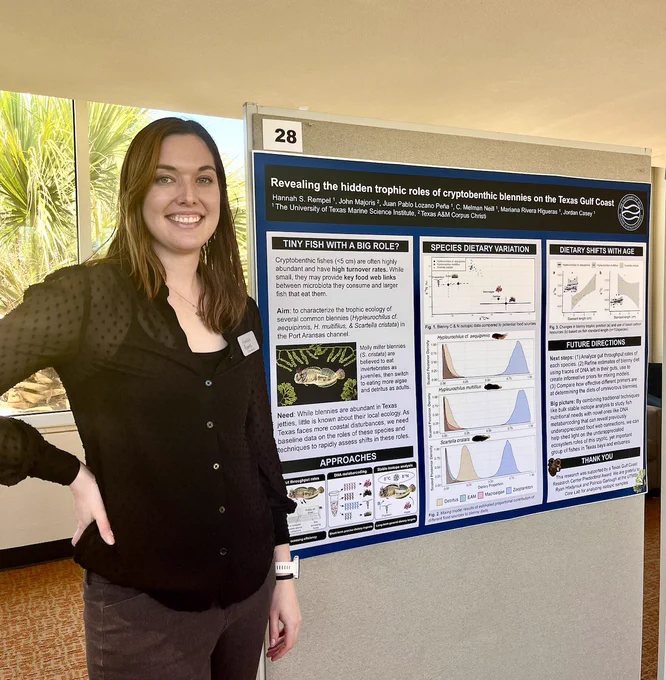 A woman stands in front of a poster on 'Revealing the hidden trophic roles of cryptobenthic fishes on the Texas Gulf Coast'