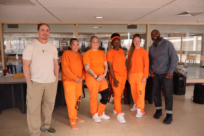 Freedom Reads team members and women inside an Arizona prison pose for a photo.