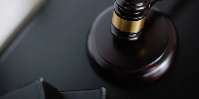 The image shows a gavel on a desk.
