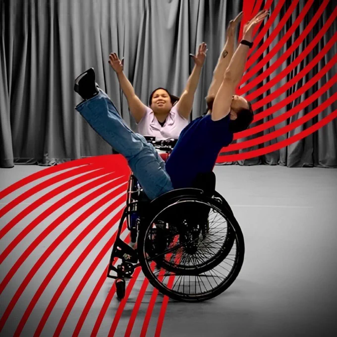 Two artists in wheelchairs posing as part of a dance performance rehearsal