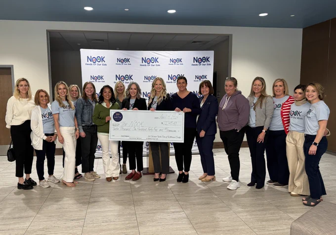 A large group of women holding a giant check