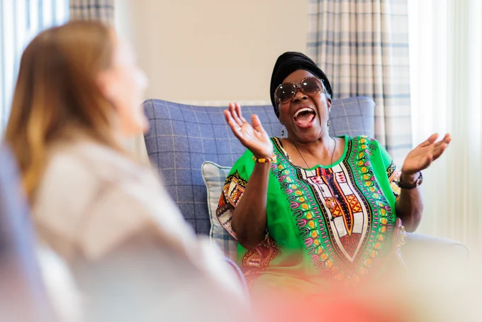 An older lady laughing with a younger colleague