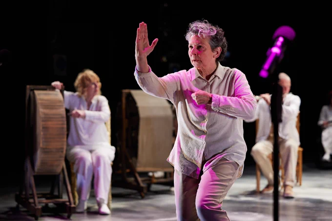 A person in a white shirt and trousers doing a karate move.