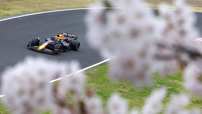 Max Verstappen on track in Suzuka with Cherry Blossom blurred out in the foreground