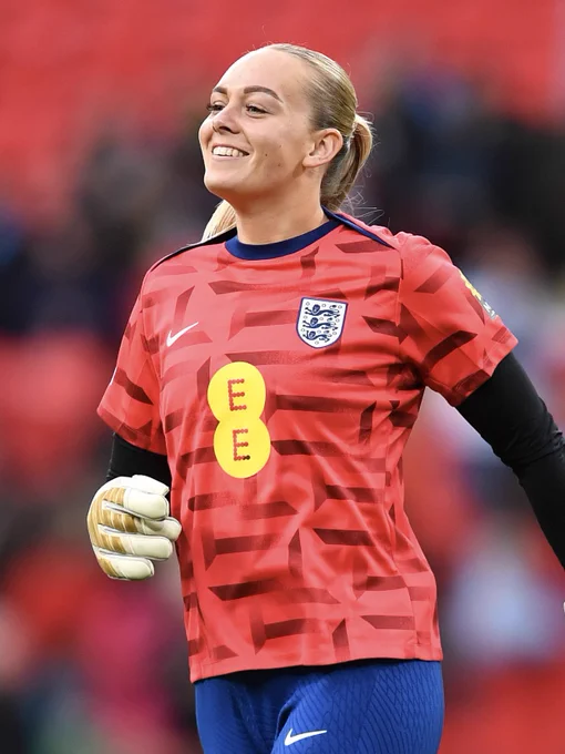 Kayla Rendell smiles during the warm-ups for England’s Womens team at Wembley Stadium, wearing a red England warm-up top with blue tracksuit trousers