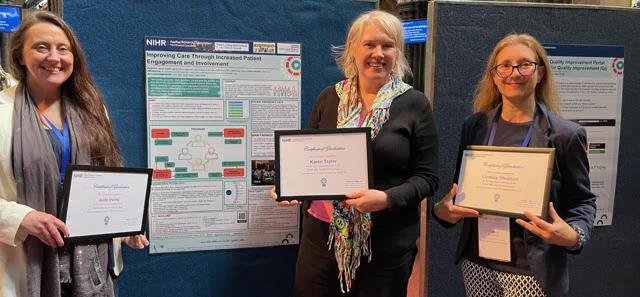 Three women (Jude, Karen & Lindsey) holding certificates and smiling in front of a poster 