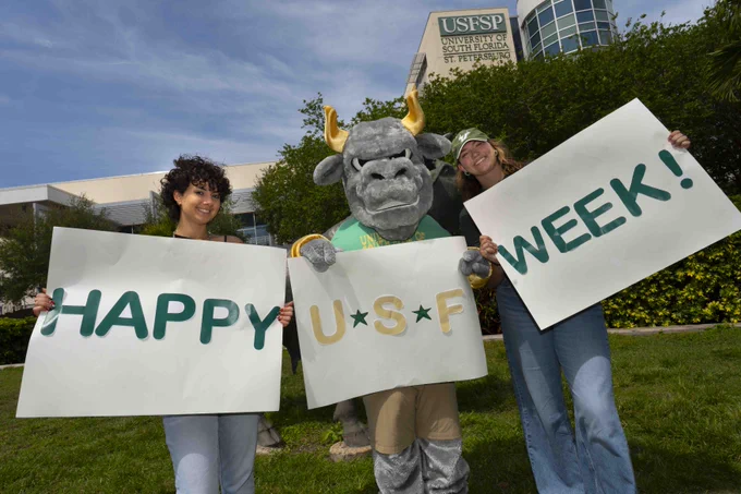 Rocky and two students holding up signs that say "Happy USF Week!"