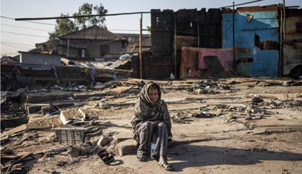 A woman sits among the debris of demolished buildings in the historic Piassa neighbourhood of Addis Ababa. A government redevelopment project is transforming the area, and people are being forced to move. Photograph: Michele Spatari/AFP/Getty Images.