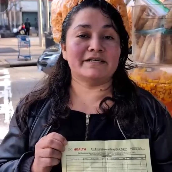 Ana, a street vendor, holding up a DC Department of Health cease and desist letter.