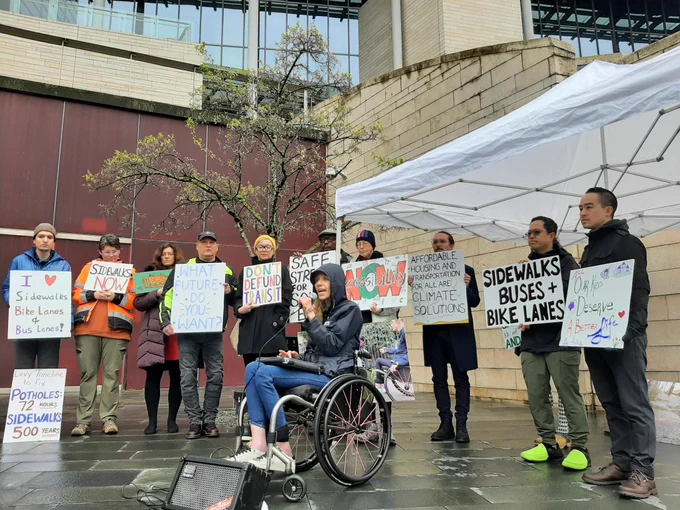 people with signs and speaking at a press conference 