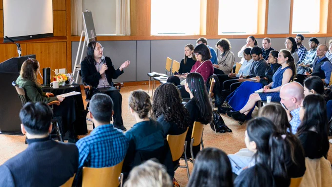 Audrey Tang, digital minister and chair of the National Institute of Cyber Security, gesticulates while sharing the collaborative, plurality-based Taiwan Model for AI development during a dialogue staged by The Burnes Center for Social Change at Northeastern University in Boston, Massachusetts.