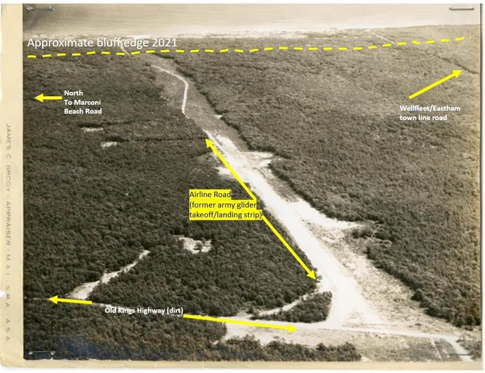 Old black and white aerial photo of the runway in the Wellfleet woods with roads and directions labeled.