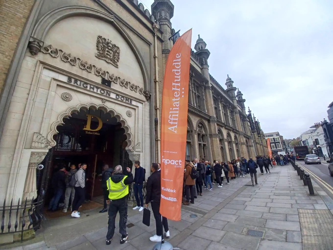 a photo of a queue outside Brighton Dome, including a flag for Affiliate Huddle
