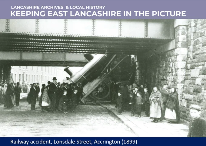 Black and white photograph showing a train falling from a railway bridge and people stood around looking at it in 1899