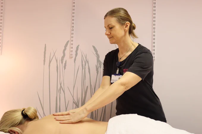 A massage therapist delivering a back massage on a woman