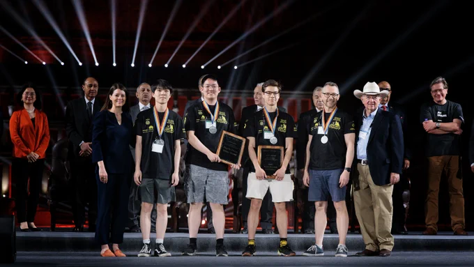 In the photo is Waterloo's trio of algorithmic coders at the 47th ICPC World Finals on the stage receiving their silver medals. 

In the spotlight are Andrew Qi Tang (4A CS, C&O minor), Kevin Wan (4A CS/C&O Double Major), Ramazan Rakhmatullin (MMath C&O) and Cheriton School of Computer Science Professor Troy Vasiga.