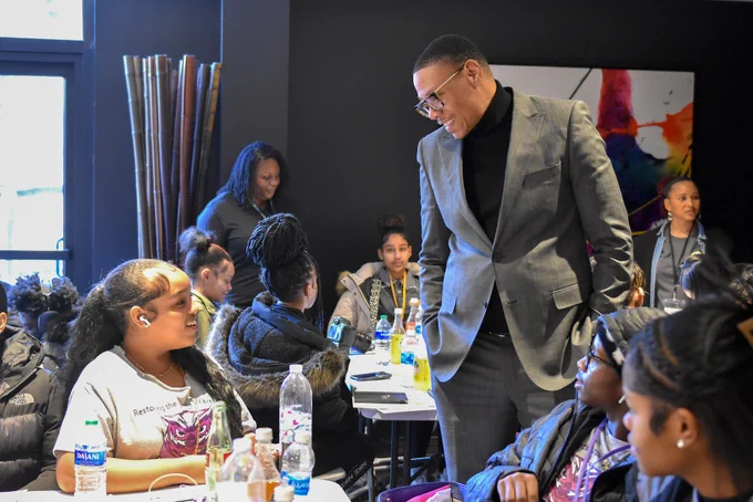 Chancellor Ferebee shares a laugh with a student who is sitting at a table.