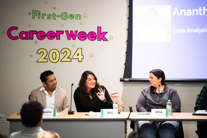 three people on a panel speak to students, on the wall behind them are the words first-gen career week 2024