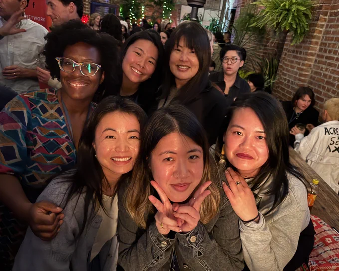 BGDM members huddle around each other for a photo a the A-Doc and BGDM meet-up, including Black Iyabo Boyd, Chinese Kitty Hu, Asian Nicole Docta, Korean Jean Rheem, and Asian Nicole Tsien.

