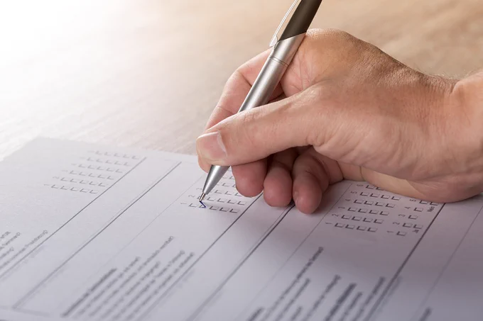 Image of a hand marking a voting ballot