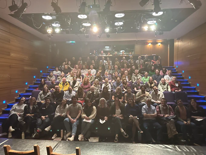 Photo of the audience at the final Page2Stage event in April 2024. Image shows a sold out audience smiling for the picture