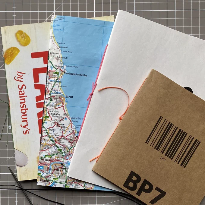 Selection of books with handmade covers including map and cereal box 