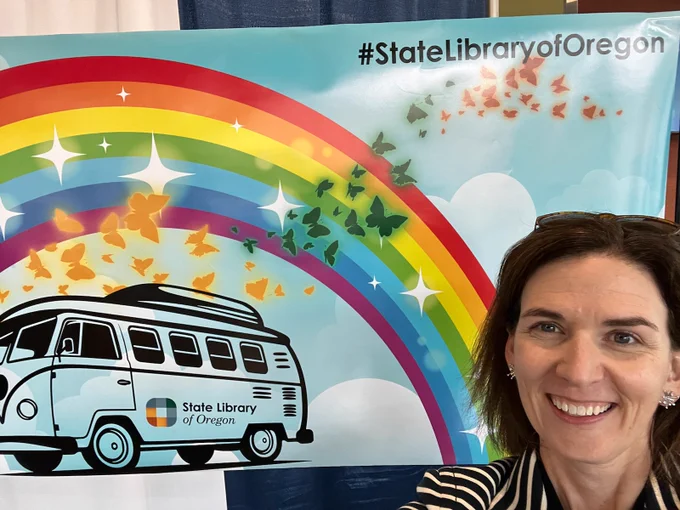 Female in front of rainbow and volks wagon bus backdrop