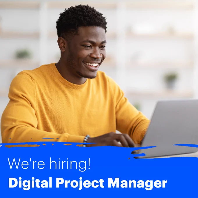 A man wearing a bright yellow jumper and smiling as he works on a laptop. Text reads: We're hiring! Digital Project Manager