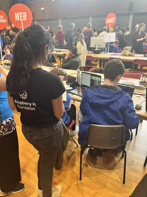 A judge from the Raspberry Pi Foundation giving feedback to a young creator on their project